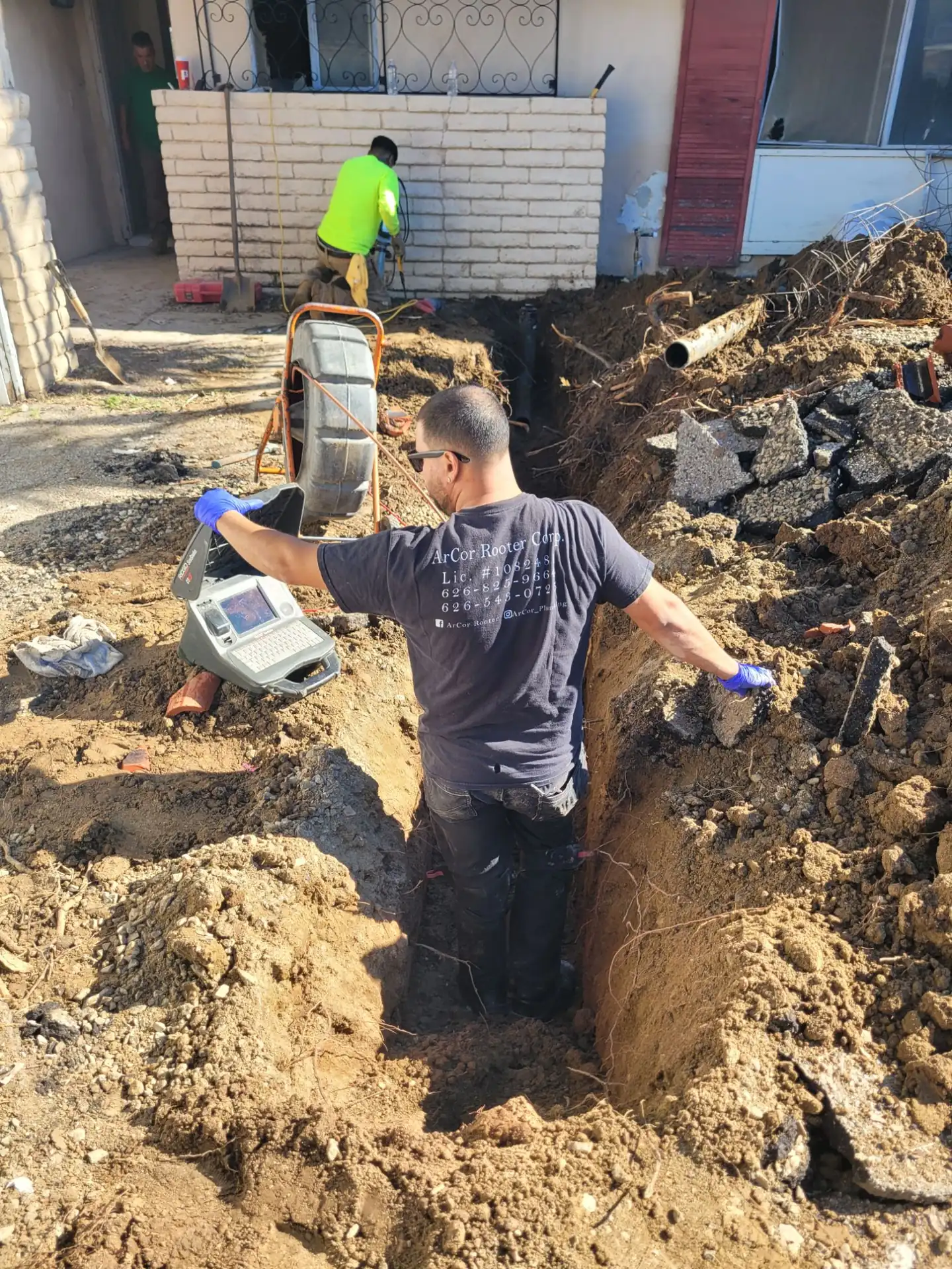 ArCor Rooter technician locating a sewer line in an open trench