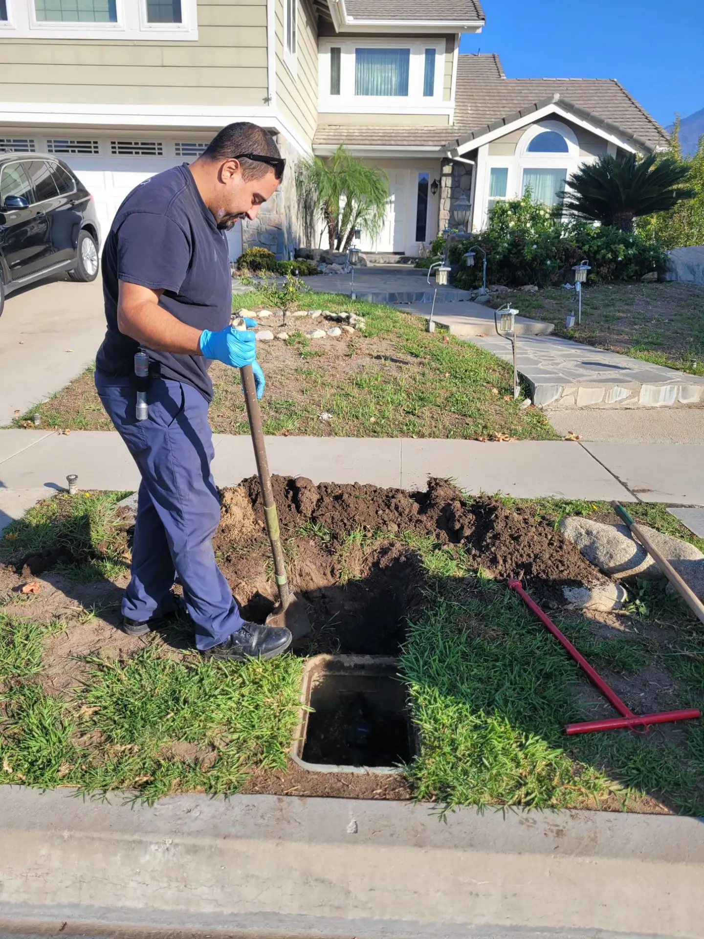 ArCor Rooter technician opening a cleanout in a front yard